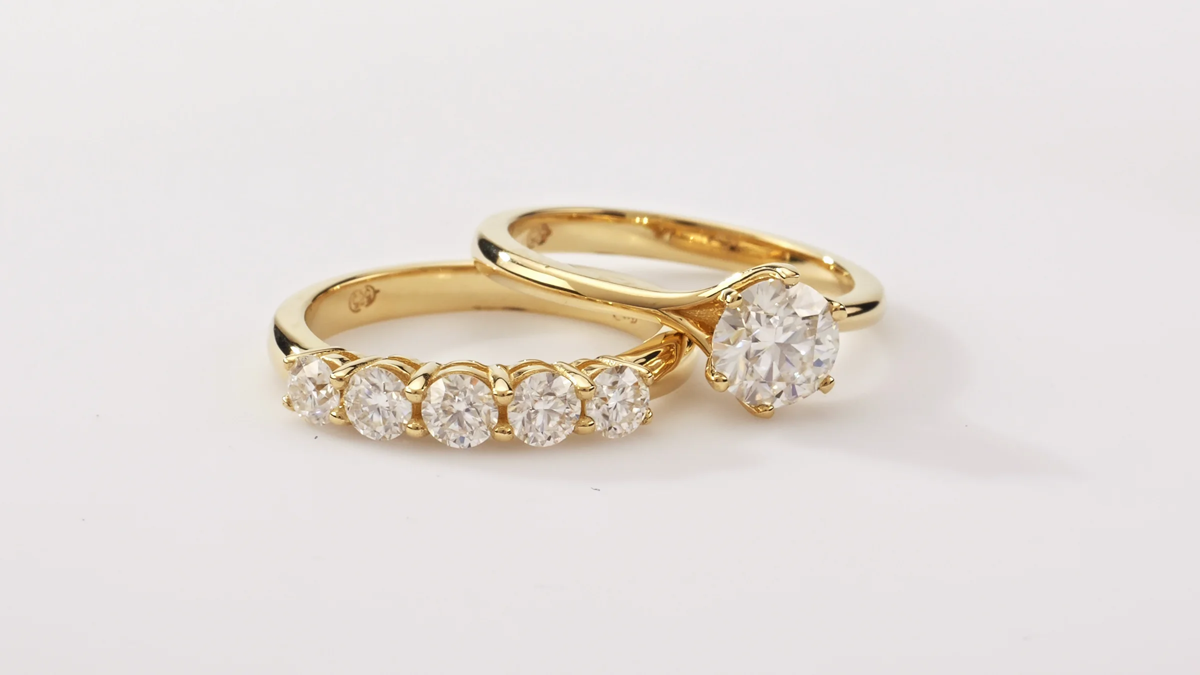 Alianças com banho de ouro e diamantes sobre fundo branco